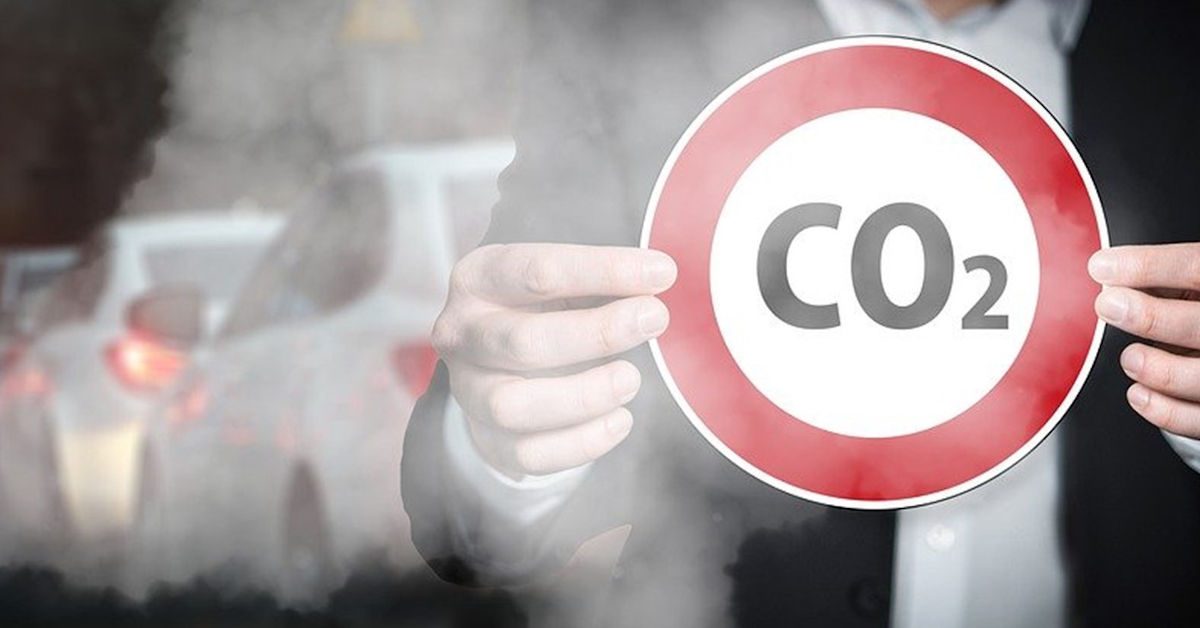 CO2 sign with cars emitting exhaust fumes